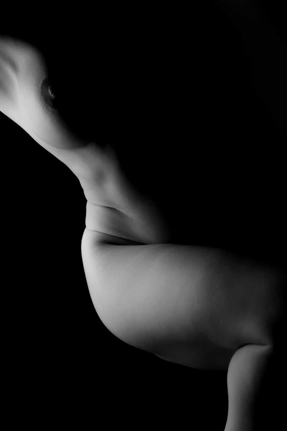 Tasteful anonymous boudoir portrait using dramatic lighting to accentuate shape and softness.