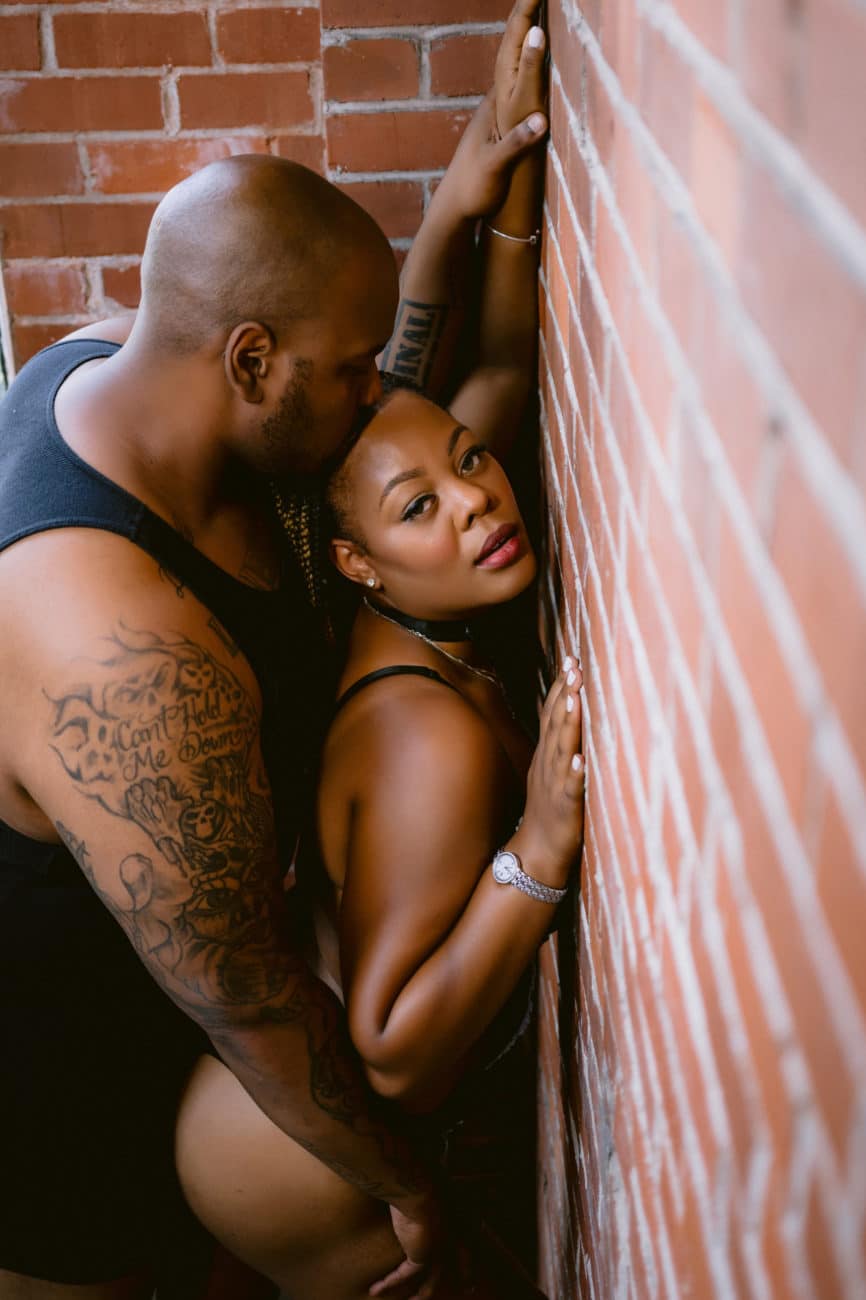 Couple against a brick wall - couples boudoir