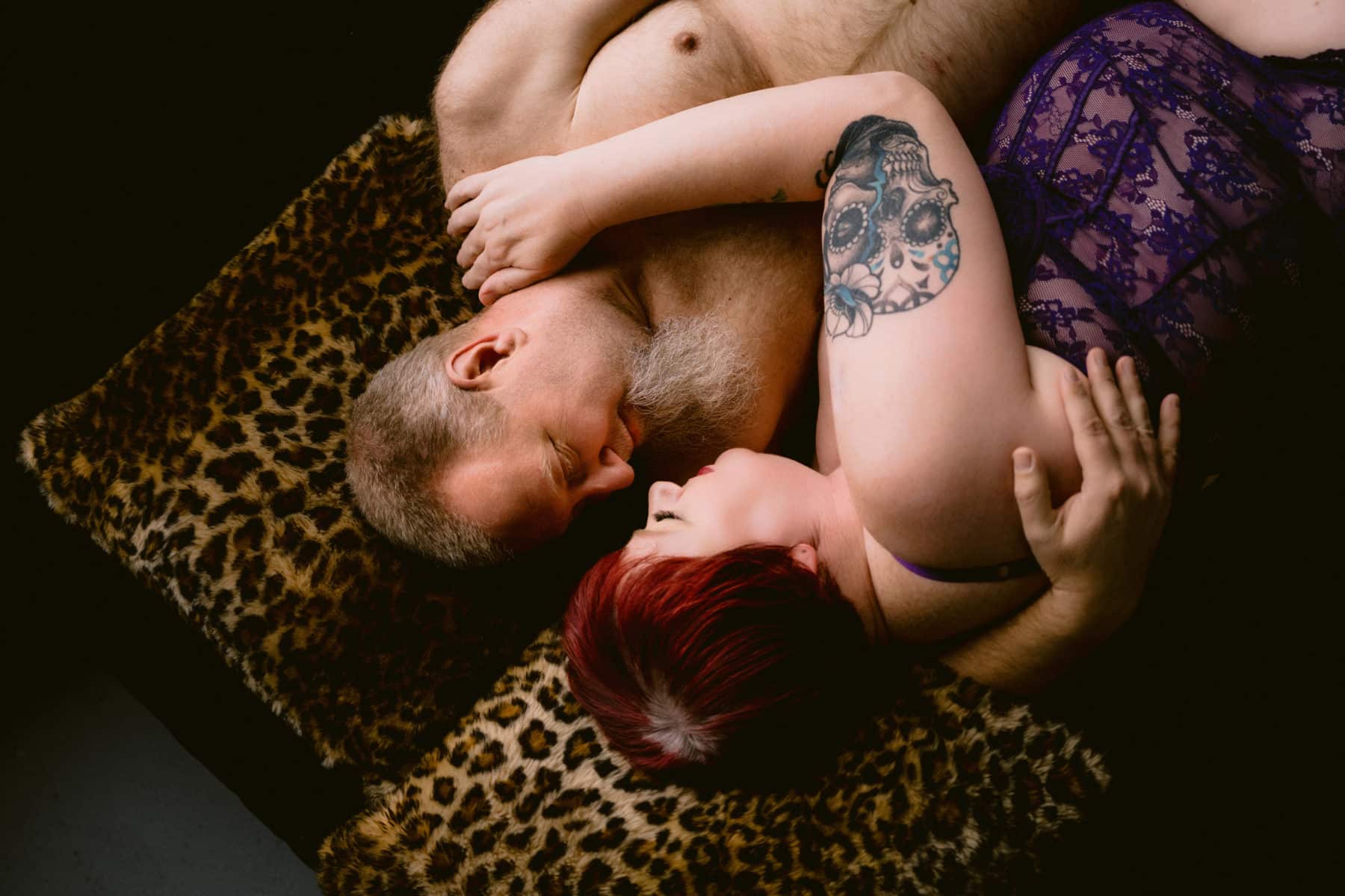 Plus size couple embracing during couples boudoir session