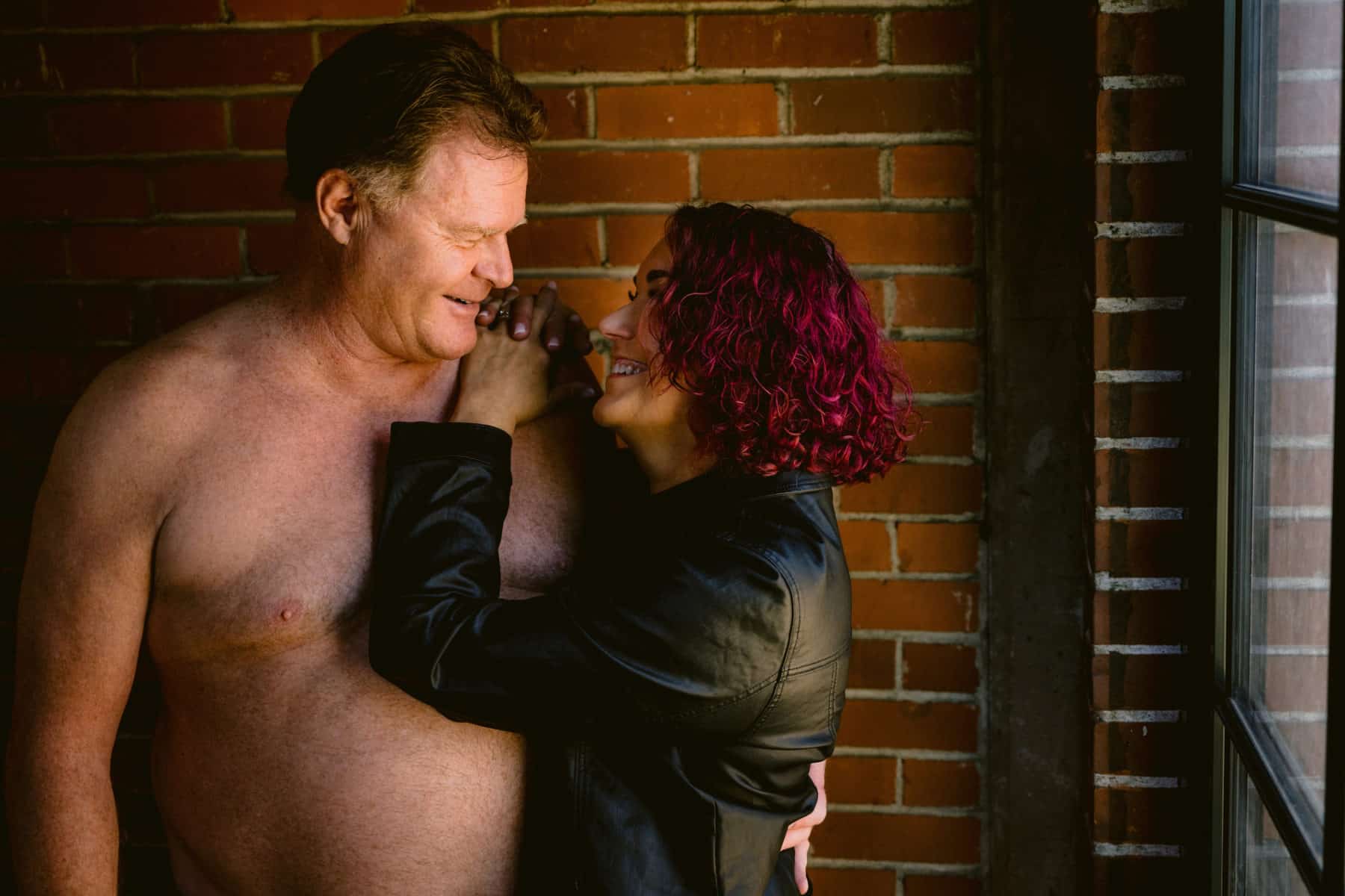 Over 60 couples boudoir smiling at each other