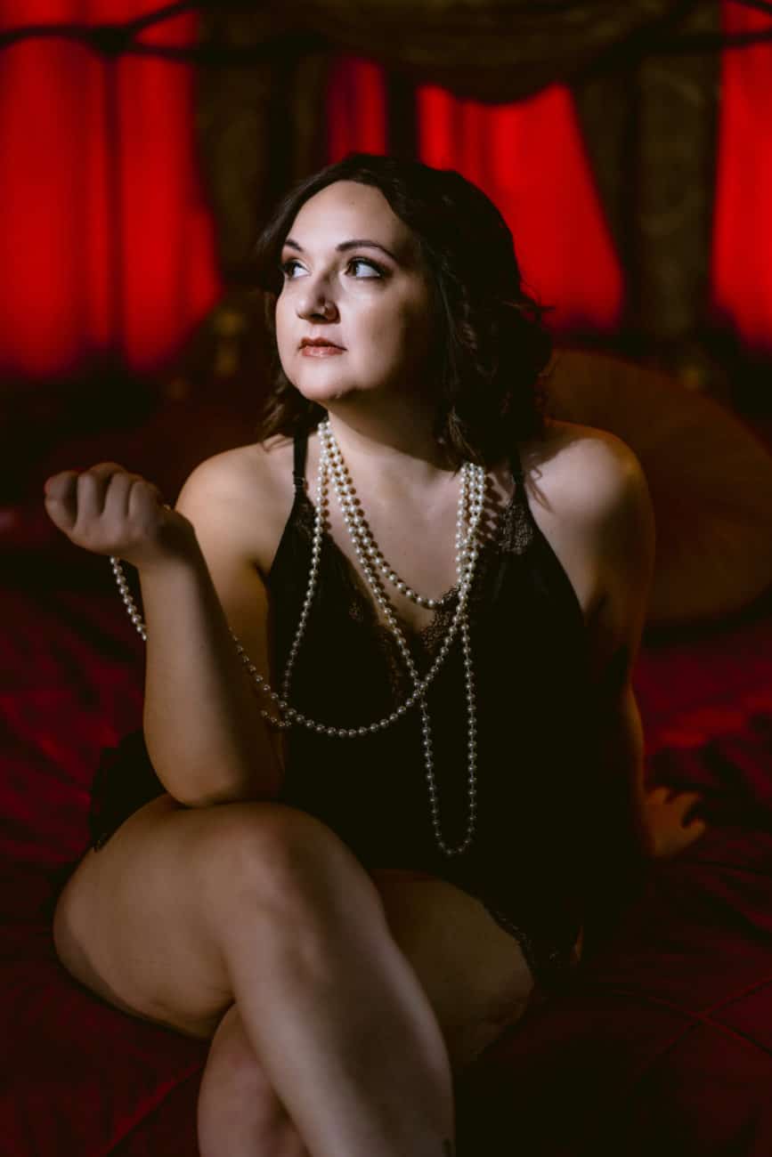 Old hollywood style boudoir photo, pearls, black lace bodysuit.
