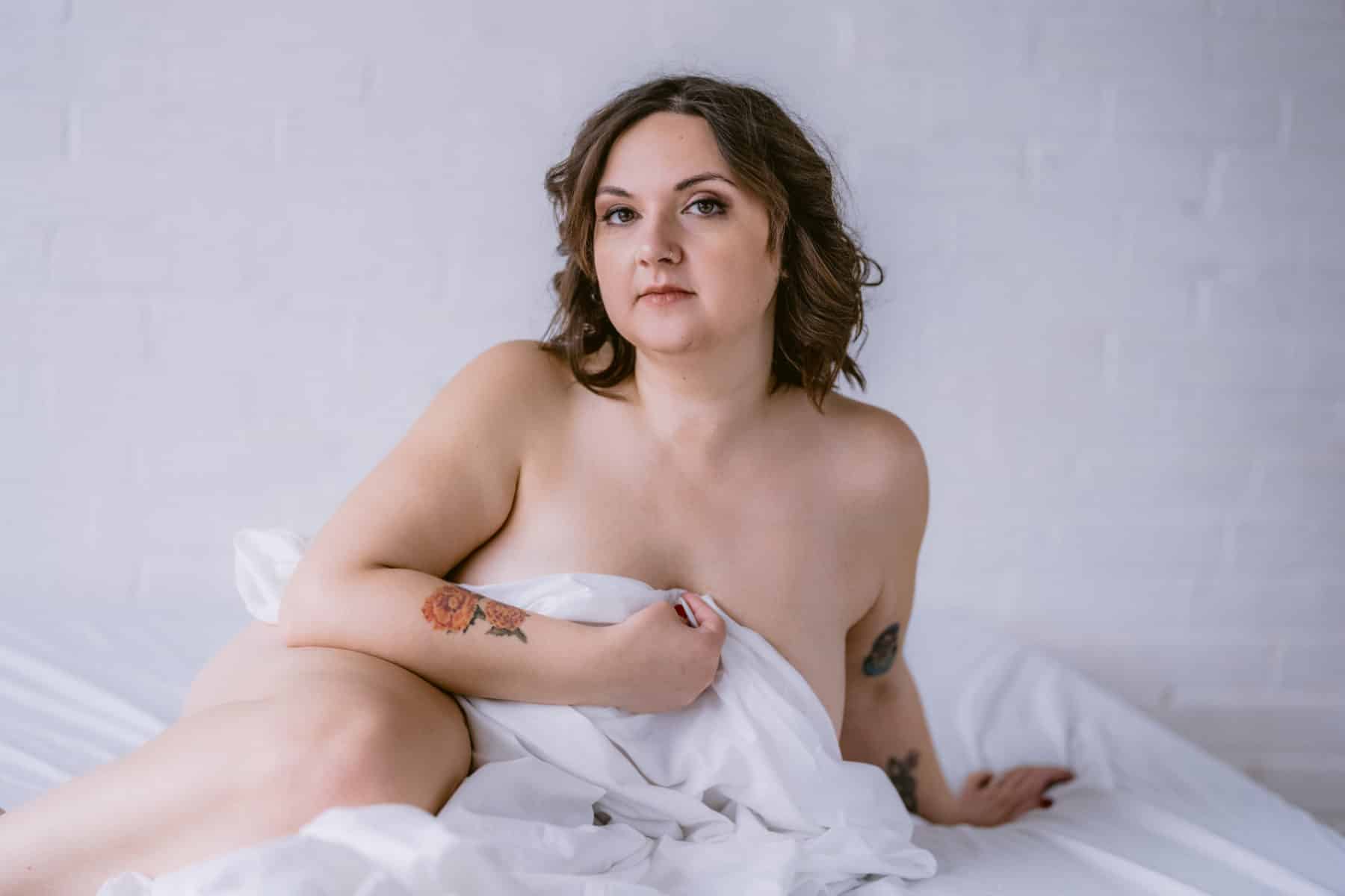 Implied nude photo with white bedding